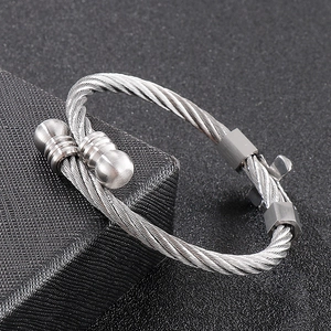 Close-up of silver wire-wrapped titanium steel cross bracelet on jewelry box