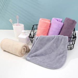 Detail view of thickened coral fleece hair towels in various colors within a bathroom setting