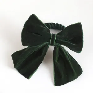Deep forest green velvet bow napkin ring with soft texture for elegant holiday table decor