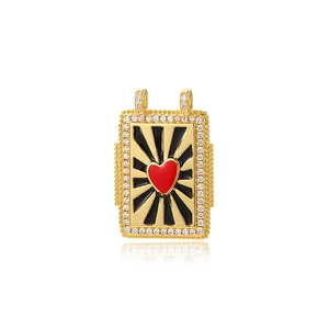 Detailed macro view of a gold tarot pendant with a red heart and sparkling rhinestones