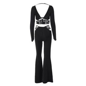 Detail of black long sleeve tie-back crop top and side cutout high-waist flared pants