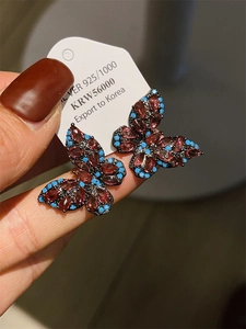 Close-up of S925 silver butterfly earrings with black metal and colorful zircon stones