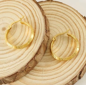 Detailed macro shot of 18K gold plated hoop earrings with Greek key engraved pattern