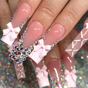 Detail of pink long coffin press-on nails with 3D bows and sparkling rhinestones