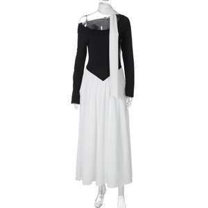 Detail of elegant black long-sleeve top and white pleated skirt with matching scarf