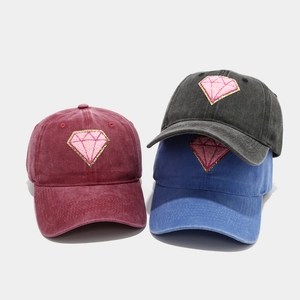 Detailed close-up of three washed cotton baseball caps with pink diamond embroidery decor