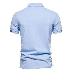 Détail du dos du polo bleu clair avec poignets rayés et texture en coton respirant