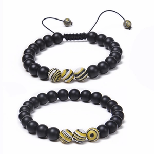 Détail d'un ensemble de bracelets en perles noires mates de 8 mm avec accents rayés