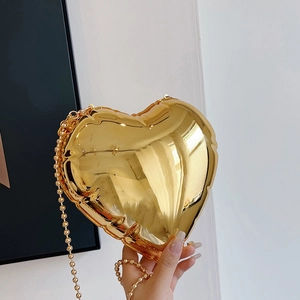Detailed view of a metallic gold heart-shaped mini bag with reflective balloon texture