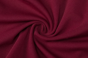 Gros plan du tissu en maille bordeaux montrant la texture tissée et le drapé fluide