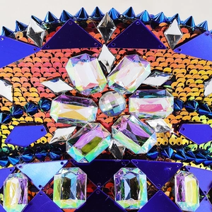 Detailed close-up of blue rivets, orange sequins, and crystal flower pattern on a punk hat