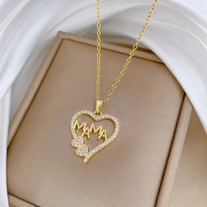 Macro detail of gold-plated heart necklace with MAMA letters and sparkling zircons