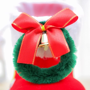 Close-up of a red flocked Christmas boot with white plush trim and festive golden bells
