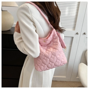 Detail of pink heart-quilted tote bag with matching round coin purse on a shoulder strap