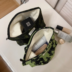 Vintage green and black jacquard canvas cosmetic bags in a 2-piece set on a white desk
