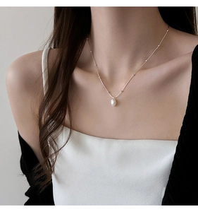 Close-up of a fashion necklace with an irregular freshwater pearl pendant on a silver chain