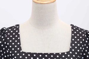 Close-up of the square neckline and white polka dots on black vintage style dress
