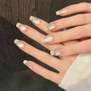 Faux ongles faits main œil de chat élégants avec pointes françaises et strass brillants