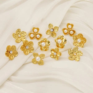 Detailed macro view of 18K gold plated flower earrings with pearls and crystal centers