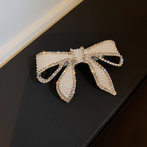 Gros plan d'une pince à cheveux nœud avec perles blanches et strass étincelants