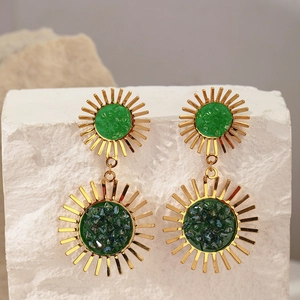 Macro detail of sun flower zircon earrings with green center on stone pedestal