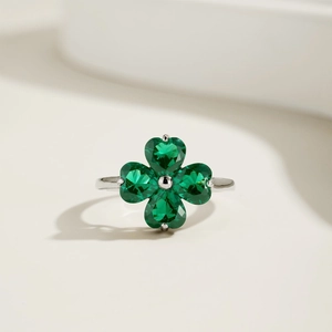 Macro detail of silver ring featuring green heart-shaped clover zircon stones
