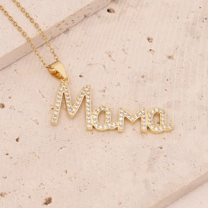 Macro detail of 18K gold plated Mama pendant necklace with inlaid zircon crystals