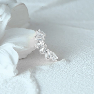 Detail of s925 silver ear stud featuring moon-shaped setting with baguette-cut zircons