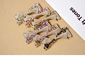 Detailed view of elegant bow hair clips with pearls and rhinestones in various colors