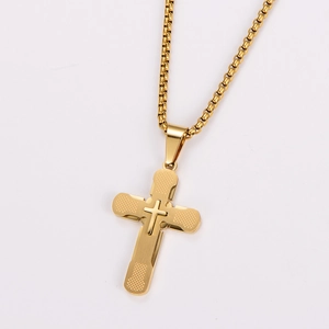 Detail view of gold layered cross pendant necklace with textured finish and box chain