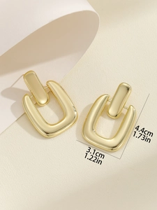 Dettaglio di orecchini geometrici dorati con misure precise di 4,4 cm per 3,1 cm