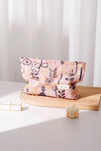 Detail of pink floral embroidery on a sturdy cotton fabric makeup pouch with zipper