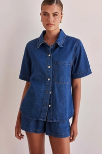 Detail of dark blue washed denim shirt with chest pocket and matching shorts