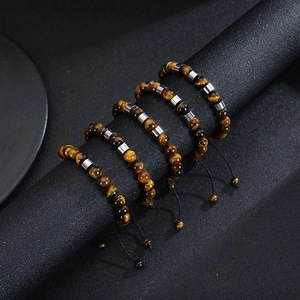 Detail shot of five tiger eye beaded bracelets displayed on a matte black jewelry stand