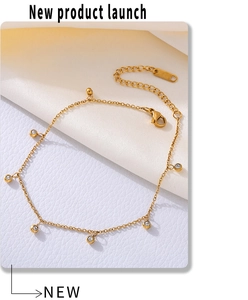 Detailed close-up of gold stainless steel anklet with lobster clasp and round zircon charms