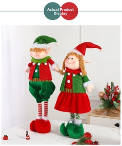Close-up of fabric Christmas elf dolls with sequined hats and striped stockings
