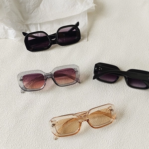 Collection of stylish square sunglasses in multiple retro colors on a neutral background