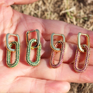 Detail of 18K gold plated earrings featuring green and pink zircon inlaid crystals