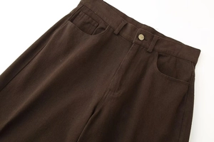Nahaufnahme brauner Denim-Hose mit diagonaler Twill-Struktur und Metallknopf-Detail