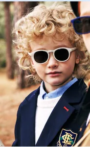 White round children's silicone sunglasses on boy in classic British school uniform