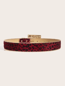 Détail de ceinture léopard rouge avec bordure perlée dorée et boucle métal gravée