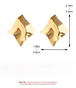 Dettaglio di grandi orecchini a onda dorati con dimensioni di 5,5 cm per 4,8 cm