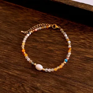 Elegant beaded bracelet with colorful natural stones and a white spindle bead on dark wood