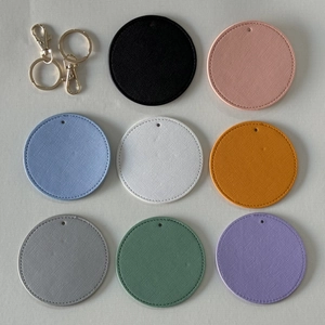 Flat lay of colorful round faux leather keychains with golden metal ring hardware