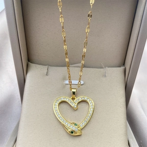 Close-up of gold heart snake pendant with white zircons and green stone eyes