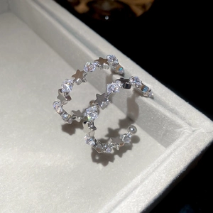 Close-up of silver C-shaped star hoop earrings with sparkling cubic zirconia on velvet
