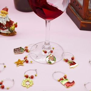 Christmas wine glass charm set with colorful enamel pendants on festive holiday table