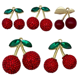 Funkelnde rote Kirsch-Anhänger mit goldenen Stielen und grünen Strassblättern