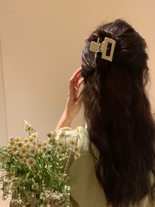 Close-up of minimalist beige acetate square hair claw clip styled in a half-up bun