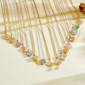 Detailed close-up of heart-shaped gold and silver necklaces with colorful zircon stones